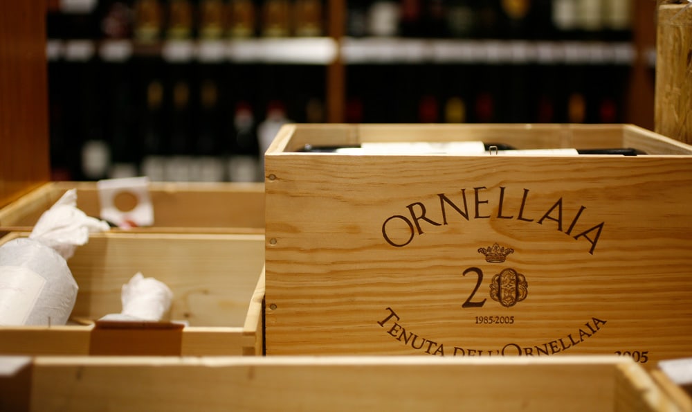 Holzkisten mit "Ornellaia Tenuta dell'Ornellaia" Schriftzug und Weinflaschen.